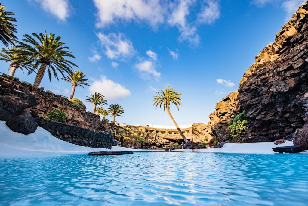 Le bassin turquoise des Jameos del Agua, entre palmiers et parois de lave